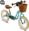 A teal balance bike with a brown seat and handlebars, and a wicker basket on the front, is shown against a white background. Voir les images du produit