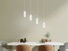 A dining table with chairs and pendant lights hanging above. Anteprima dell’immagine prodotto