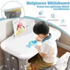 A young child is drawing on a white board at a desk. Produktbild-Vorschau