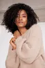 A woman wearing a beige sweater. Produktbild-Vorschau