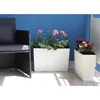 A balcony setting with a chair and two planters filled with flowers. Produktbild-Vorschau