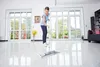 A woman is mopping a shiny floor in a bright, modern room with large windows. Voir les images du produit