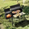 A charcoal grill with food cooking on it, placed on a grassy lawn. Náhled obrázku produktu