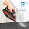 A person ironing clothes with a spray bottle icon indicating water spraying. Voir les images du produit