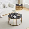 A living room scene featuring a white sofa and two round coffee tables with black marble-effect tops and gold metal frames. Voir les images du produit