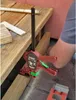 A person is using a clamp to hold wooden planks together, likely for construction or DIY. Náhled obrázku produktu