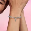 A close-up shot of a person's arm wearing a silver chain bracelet with a small cross charm. Produktbild-Vorschau