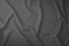 A close-up, top-down view of a crumpled grey satin bedsheet with a subtle striped pattern. Produktbild-Vorschau