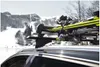 A car with skis mounted on a roof rack in a snowy mountain landscape. Podgląd zdjęcia produktu