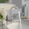A bathroom sink with a faucet running water, surrounded by decorative items. Produktbild-Vorschau