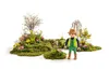 A Playmobil gardener figure stands in a miniature garden setting with mossy mounds and flowers. Náhľad obrázku produktu
