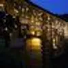 A string of LED lights is illuminated and reflected in water. Produktbild-Vorschau