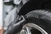 A gloved hand is applying a product to a car tire. Anteprima dell’immagine prodotto