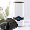 A humidifier is being filled with water, with a digital display showing temperature and humidity. Voir les images du produit