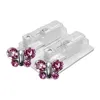 Two butterfly-shaped earrings with pink stones, presented in clear plastic packaging with two piercing devices. Produktbild-Vorschau