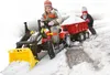 Two children playing in the snow with a toy tractor and trailer. Produktbild-Vorschau
