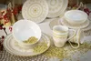 A set of white and gold mandala-patterned ceramic dishes and mugs, scattered with gold glitter. Náhľad obrázku produktu