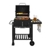 A black charcoal grill with food cooking on it, set against a white background. Produktbild-Vorschau