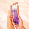 Hands holding a bottle of Durex massage gel. Podgląd zdjęcia produktu