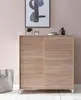 A wooden shoe cabinet with sliding doors, decorated with a framed abstract artwork and a few decorative items on top. A grey tote bag is placed next to it. Produktbild-Vorschau