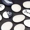 A collection of decorative stones with various designs and text, arranged on a dark surface. Produktbild-Vorschau