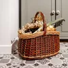 A woven basket filled with vegetables sits on a patterned floor in front of a gray cabinet. Náhľad obrázku produktu