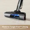 A close-up view of a vacuum cleaner head with a cutaway showing its internal mechanism, demonstrating its tangle-free feature. The background is a light-colored floor. Voir les images du produit