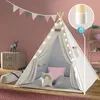 A child's play tent set up in a room, decorated with lights and pillows. Produktbild-Vorschau