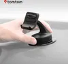 A hand is shown attaching a black TomTom GPS mount with a suction cup to a gray dashboard. Anteprima dell’immagine prodotto