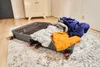 An open suitcase filled with clothes is placed on a rug in a room. Náhled obrázku produktu