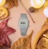 A silver Casio watch is placed on a surface with autumn leaves, cookies, and candles. Produktbild-Vorschau