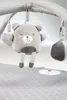 A close-up view of a baby play gym with a teddy bear toy hanging. Produktbild-Vorschau