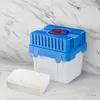 A blue and white dehumidifier unit with a red cap is shown next to a rectangular porous object on a marble-like countertop. Náhled obrázku produktu
