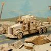 A wooden model of a heavy truck is displayed on a road with rocks and a desert-like background. Náhľad obrázku produktu