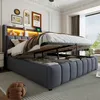 A bedroom scene with a large bed featuring an open storage compartment and built-in LED lighting in the headboard. Podgląd zdjęcia produktu
