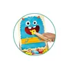 A child's hand is feeding a piece of cheese to a blue monster character using wooden tongs. Podgląd zdjęcia produktu