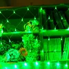 A net light curtain with green LEDs is draped over shelves filled with artificial flowers and books. Voir les images du produit