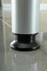 Close-up of the base of a silver and black cylindrical object, likely a desk leg, resting on a tiled floor. Anteprima dell’immagine prodotto