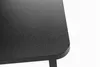 A close-up view of the textured surface and rounded corner of a black monitor stand. Náhled obrázku produktu