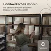 A woman is looking at a tablet in a pottery studio, surrounded by shelves of ceramic dishes. Voir les images du produit