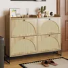 A shoe cabinet with four flip-down doors, decorated with rattan fronts, is placed in a hallway or entryway. Decorative items like a small cactus, a figurine, and a radio are on top of the cabinet. Anteprima dell’immagine prodotto