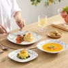 A person is eating a meal from a set of dishes on a wooden table. Produktbild-Vorschau