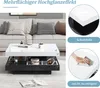 A modern living room scene featuring a coffee table with a white and black design, placed in front of a sofa. Produktbild-Vorschau