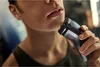 A person is shaving their face with an electric razor. Podgląd zdjęcia produktu