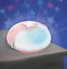 A pink star projector night light is shown on a surface, projecting stars onto a dark blue background. Náhled obrázku produktu