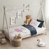 A child's bed with bedding and stuffed animals, decorated with fairy lights. Náhľad obrázku produktu