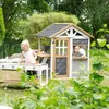 Children playing in a garden with a wooden playhouse and play kitchen. Anteprima dell’immagine prodotto