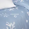 A close-up view of a blue duvet cover with a white snowflake print and a white pillow. Produktbild-Vorschau