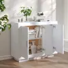 A white sideboard with its doors open, displaying books and a vase inside. The sideboard is placed in a room with natural light casting shadows. Voir les images du produit