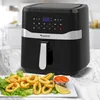A black TurboTronic air fryer is shown on a marble countertop, with a plate of fried calamari and a small dish of dipping sauce in the foreground. Produktbild-Vorschau